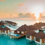 Brown and White Wooden Houses on Body of Water during Sunset