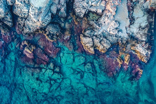 Aerial Photography of Rocks Beside Body of Water