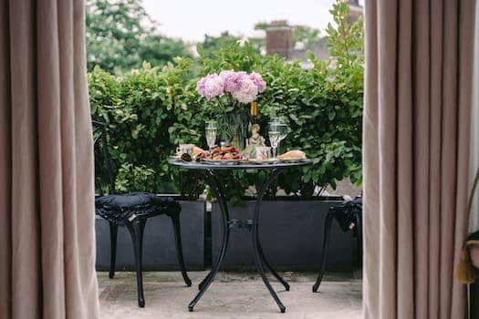 Breakfast table with elegant flowers and wineglasses on veranda of classic styled villa