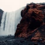 Three Men Standing Near Waterfalls