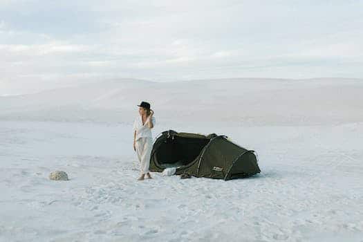 Tourist next to tent in desert in daytime