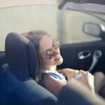 Modern woman on passenger seat in convertible