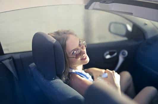 Modern woman on passenger seat in convertible