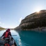 Person Riding Boat in Body of Water Between Islands