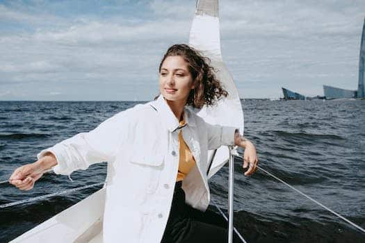 Woman in White Button Up Shirt and Black Pants Sitting on White Boat