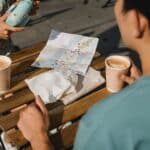 Young couple drinking coffee while using instant photo camera